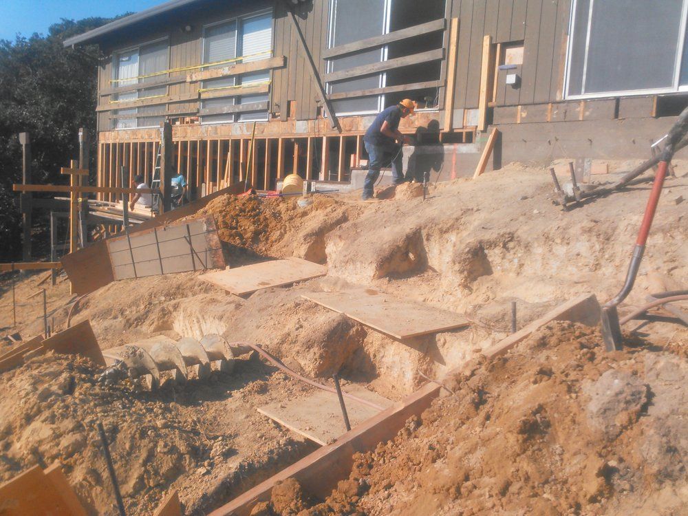 A construction site with a house in the background