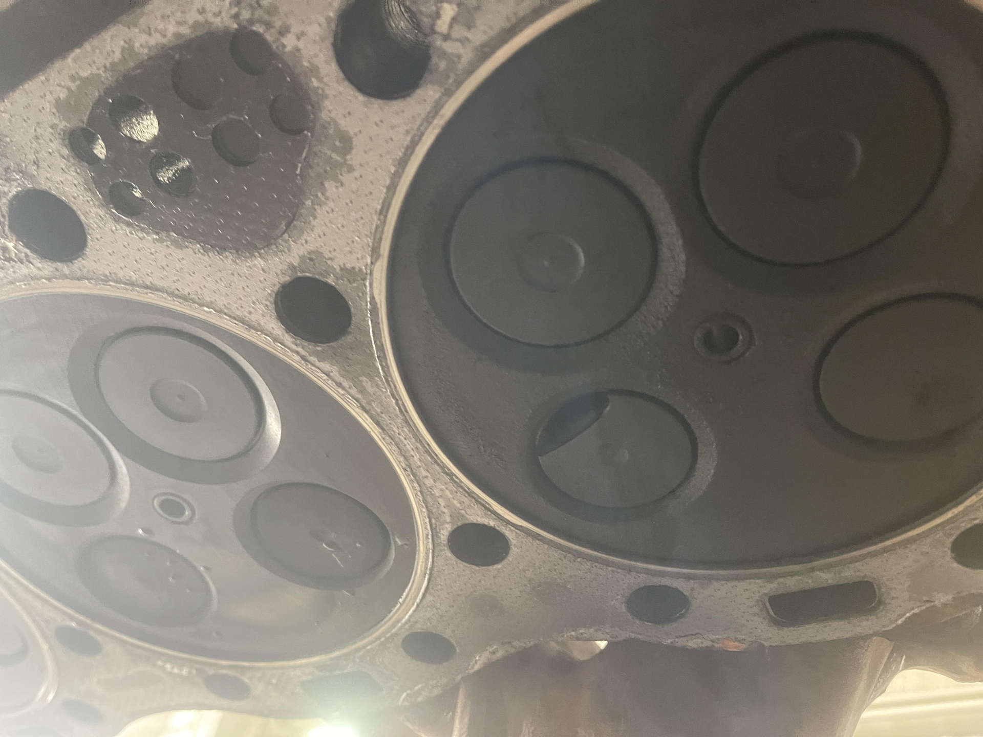 Close-up of engine cylinder head, showing valves and carbon buildup.