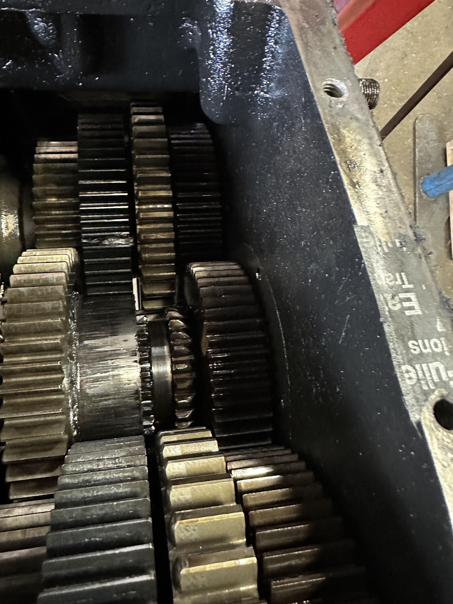 Gears inside a machine's open housing, coated in oil.