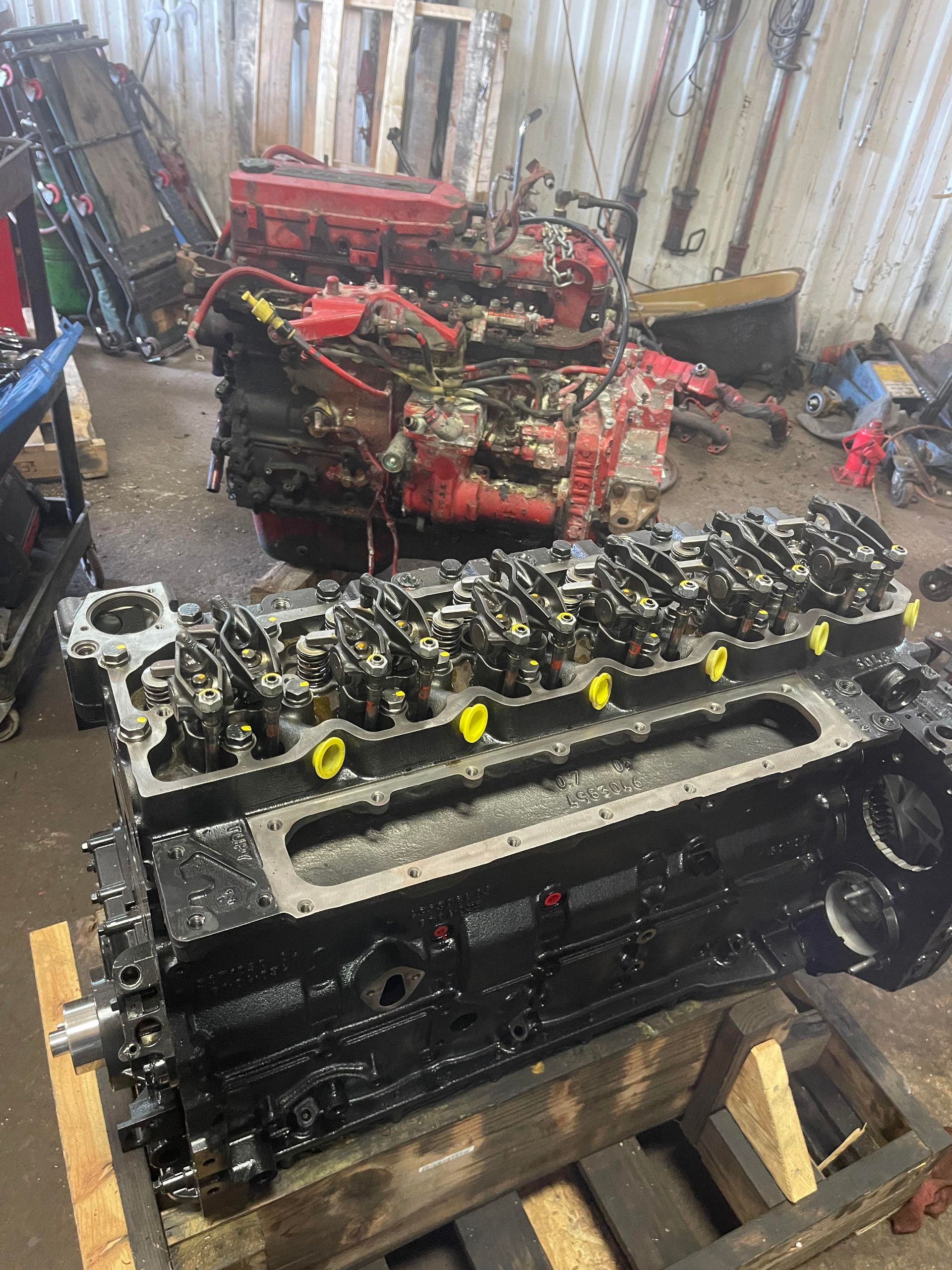 Car engine bay with diagnostic tool, wires, and tools, likely for repair.