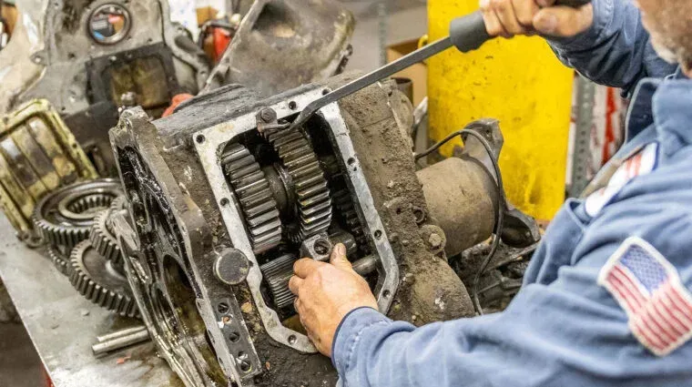 Several dismantled torque converters on a metal workbench in a workshop.
