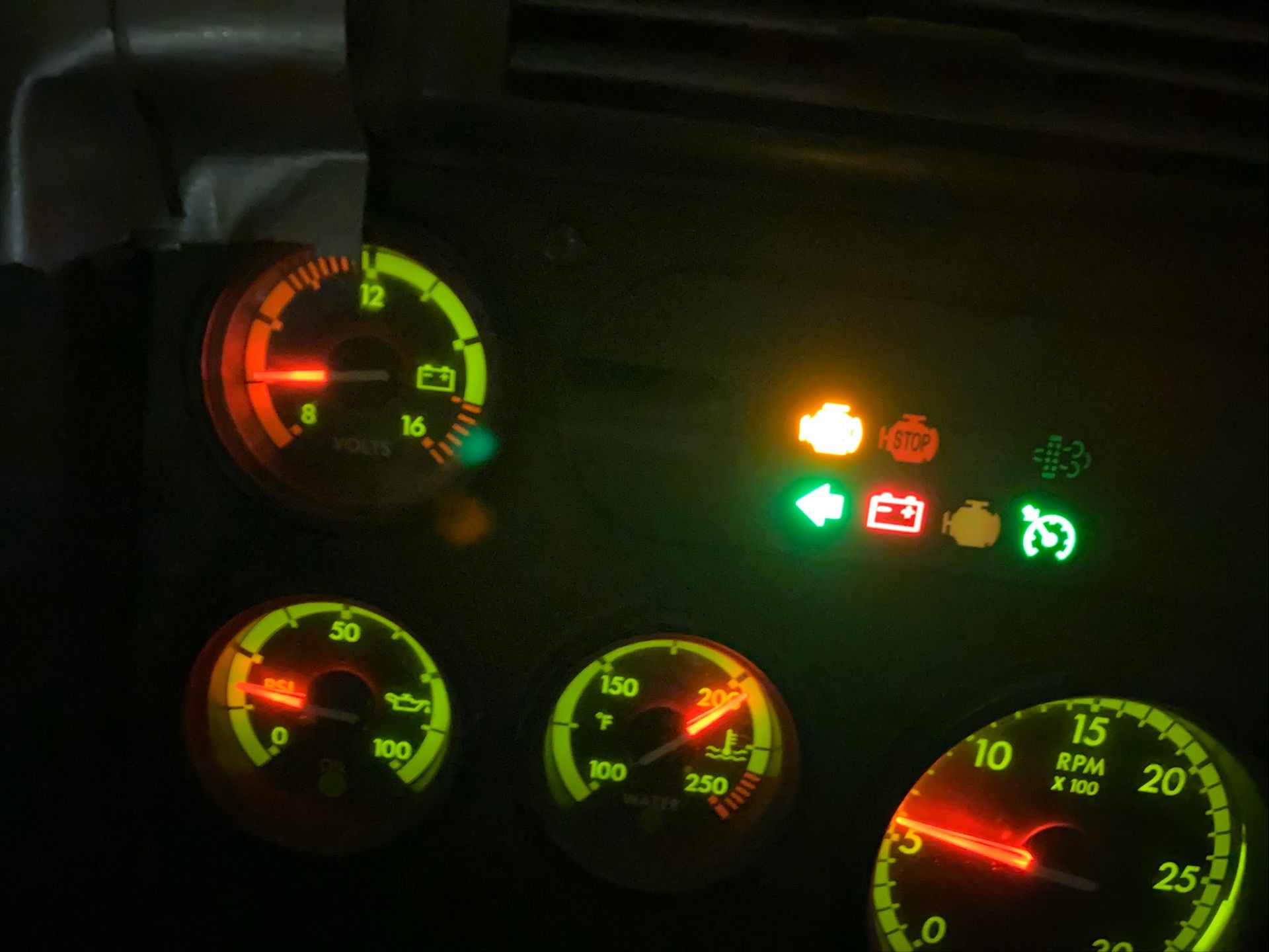 Dashboard with illuminated gauges and warning lights in green and red.