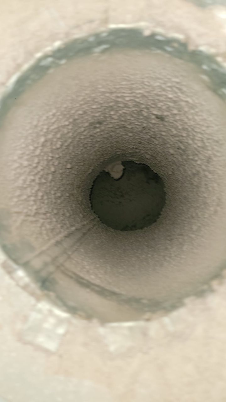 A close up of the inside of a drain with a hole in it.