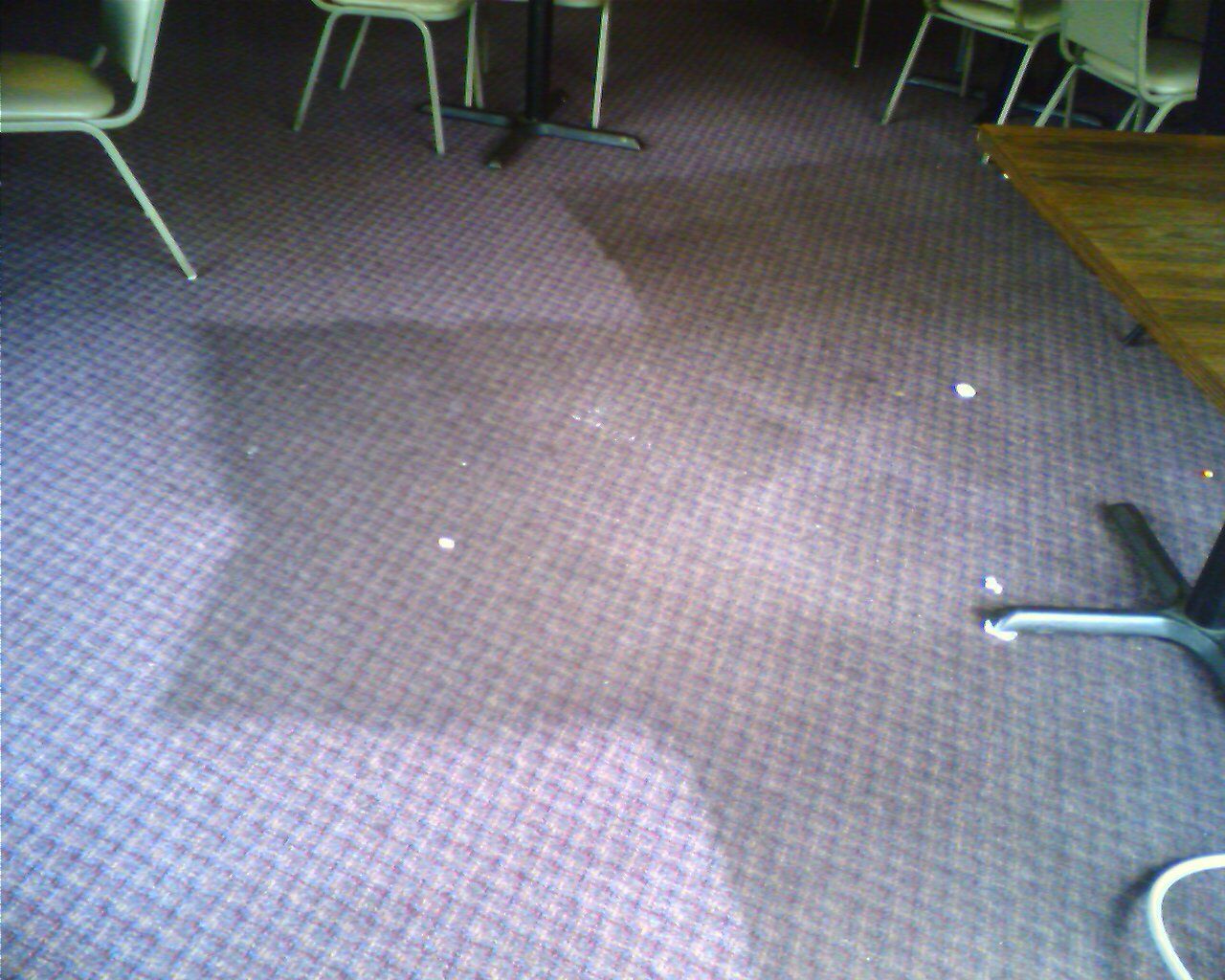 A purple carpeted floor with tables and chairs