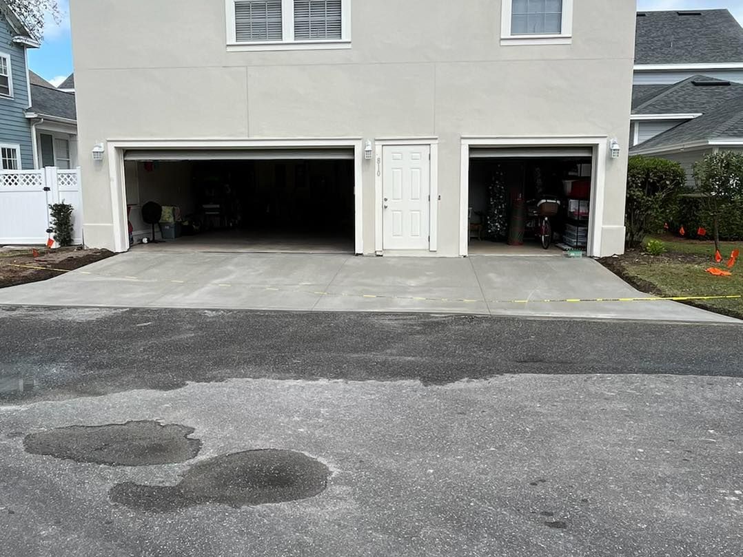 A house with a garage and a driveway in front of it.