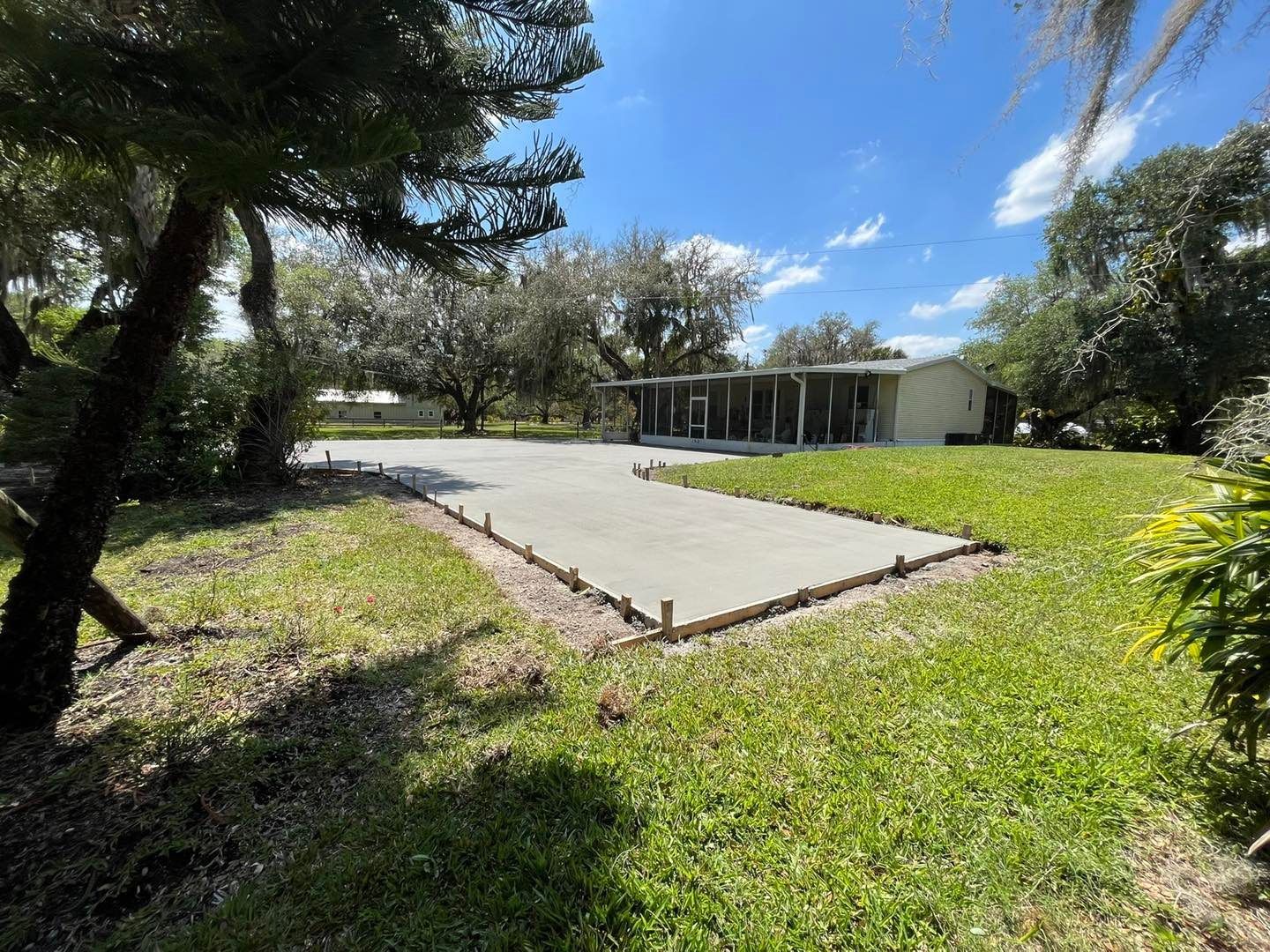 A concrete driveway is being built in front of a house.