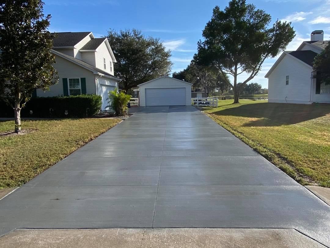 A concrete driveway leading to a house with a garage.