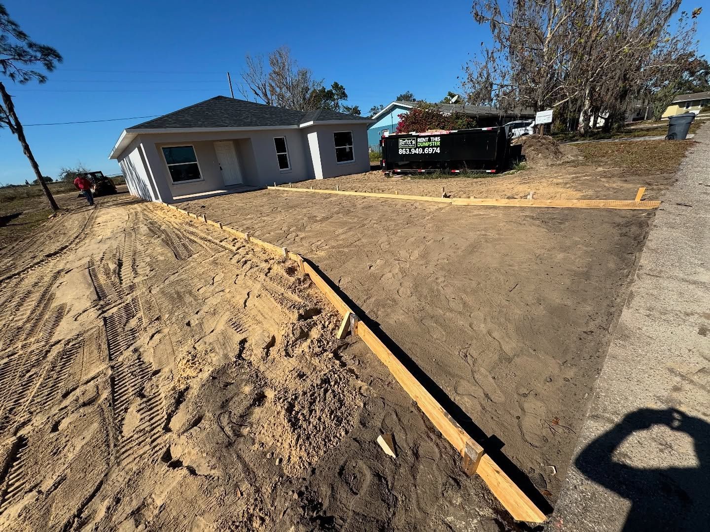 A house is being built next to a dirt road.