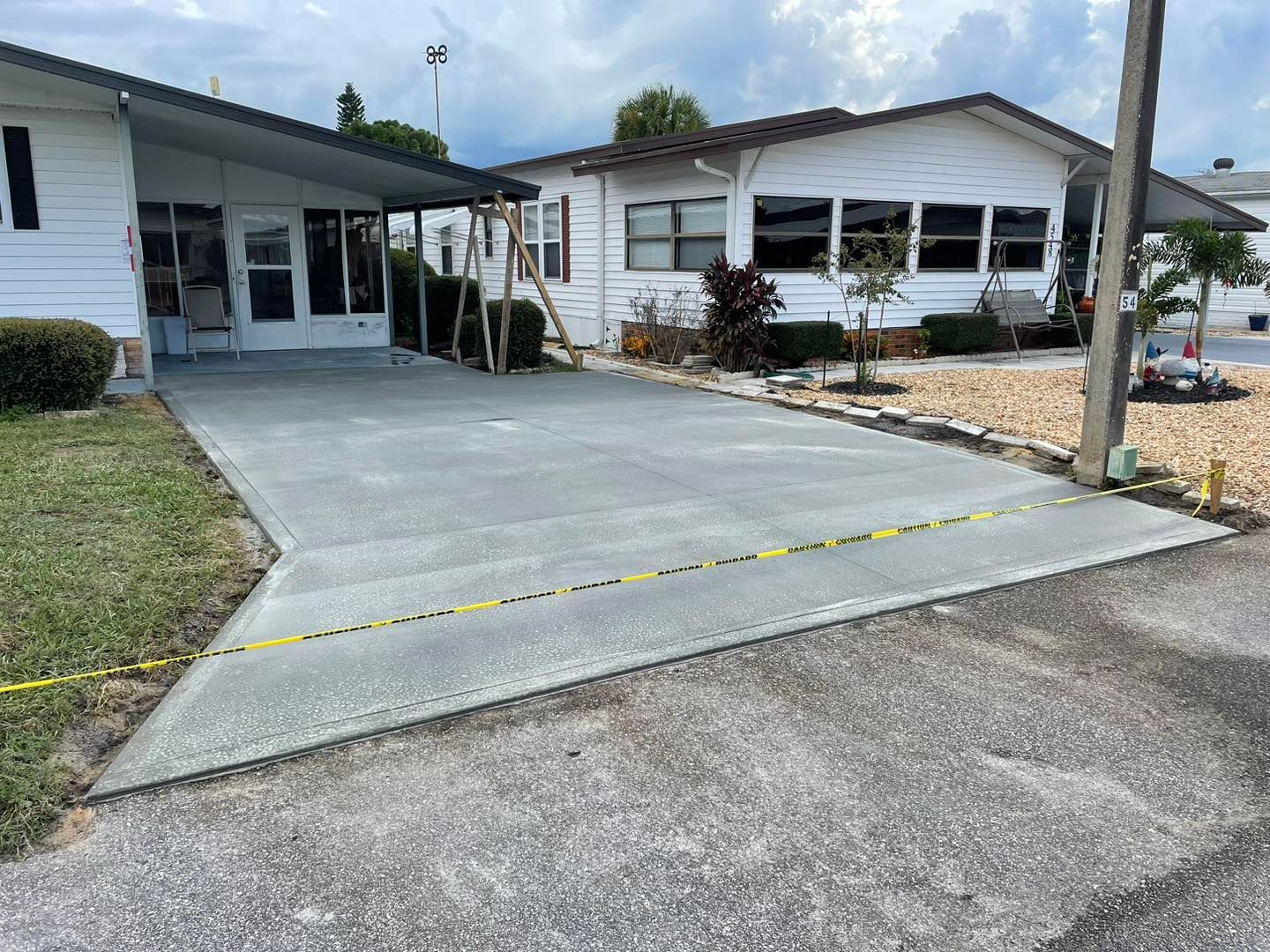 A concrete driveway is being built in front of a mobile home.