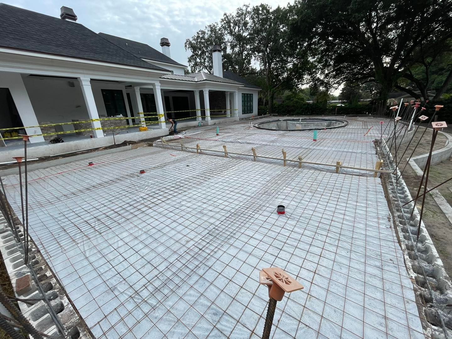 A swimming pool is being built in the backyard of a house.