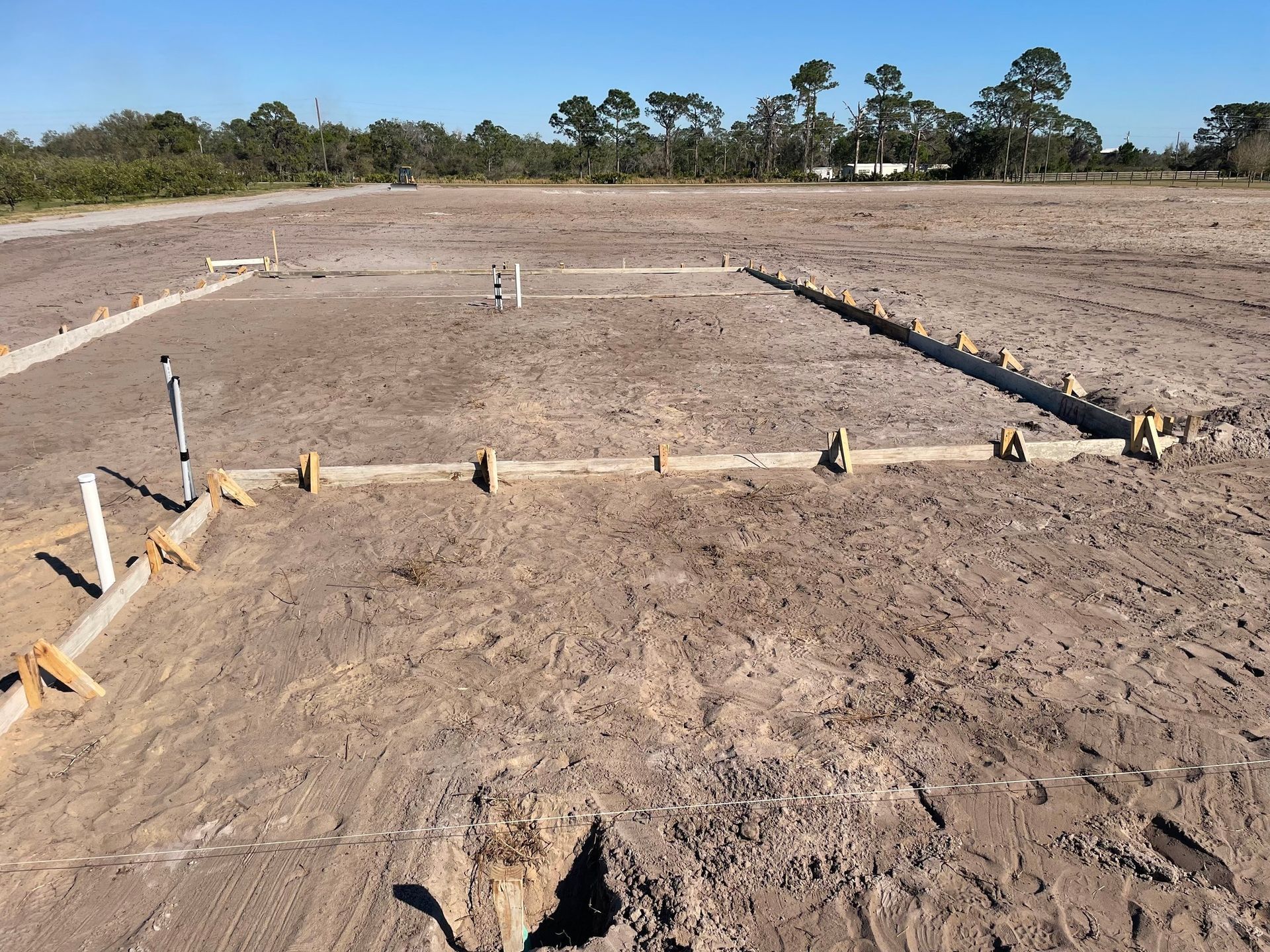 A dirt field with a few trees in the background