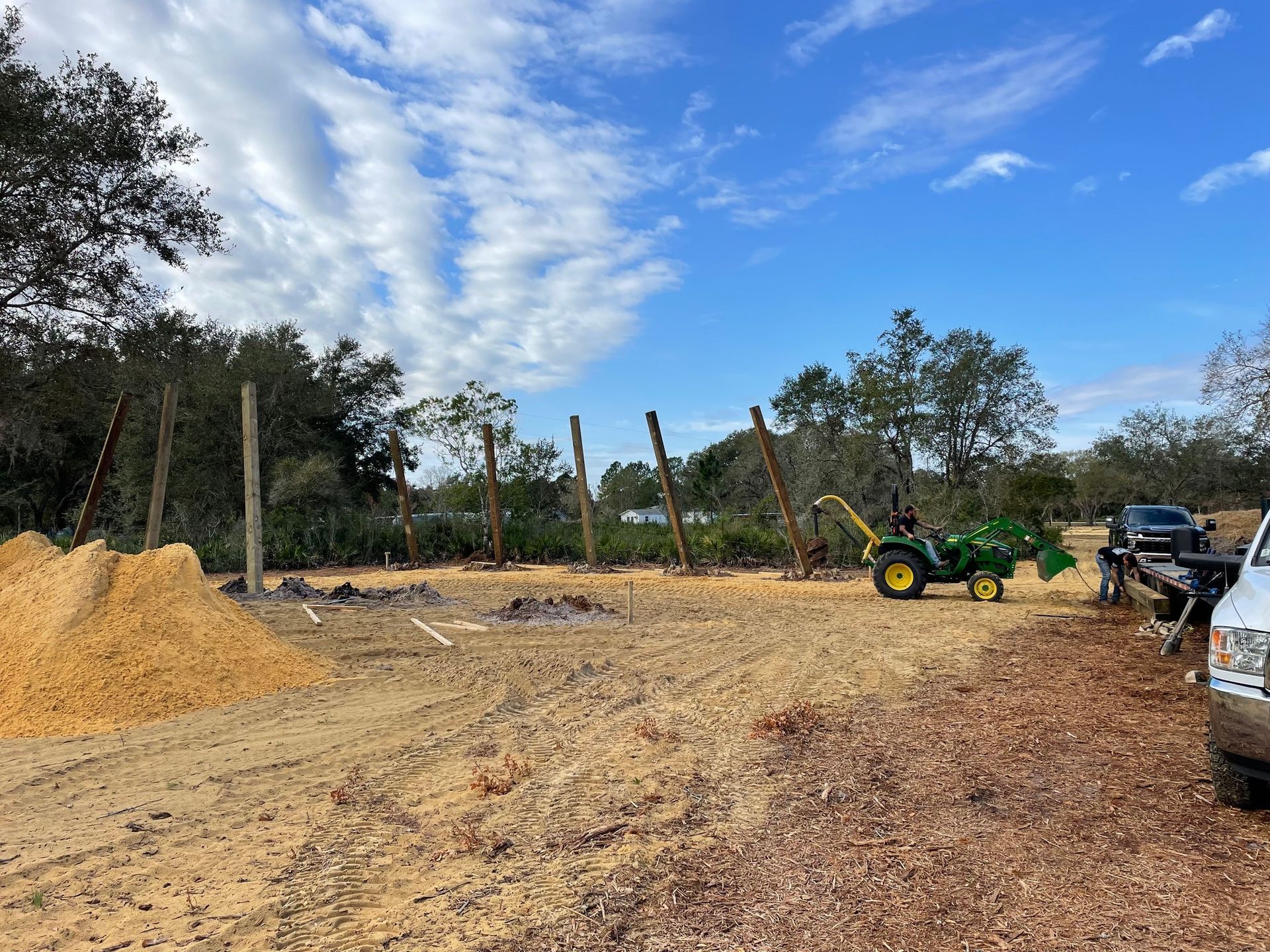A tractor is parked in the middle of a dirt field.