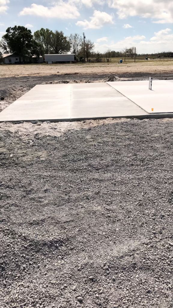 A large concrete slab is sitting on top of a gravel field.