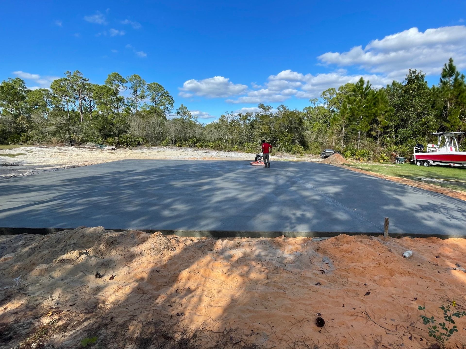 A man is standing on top of a concrete driveway.