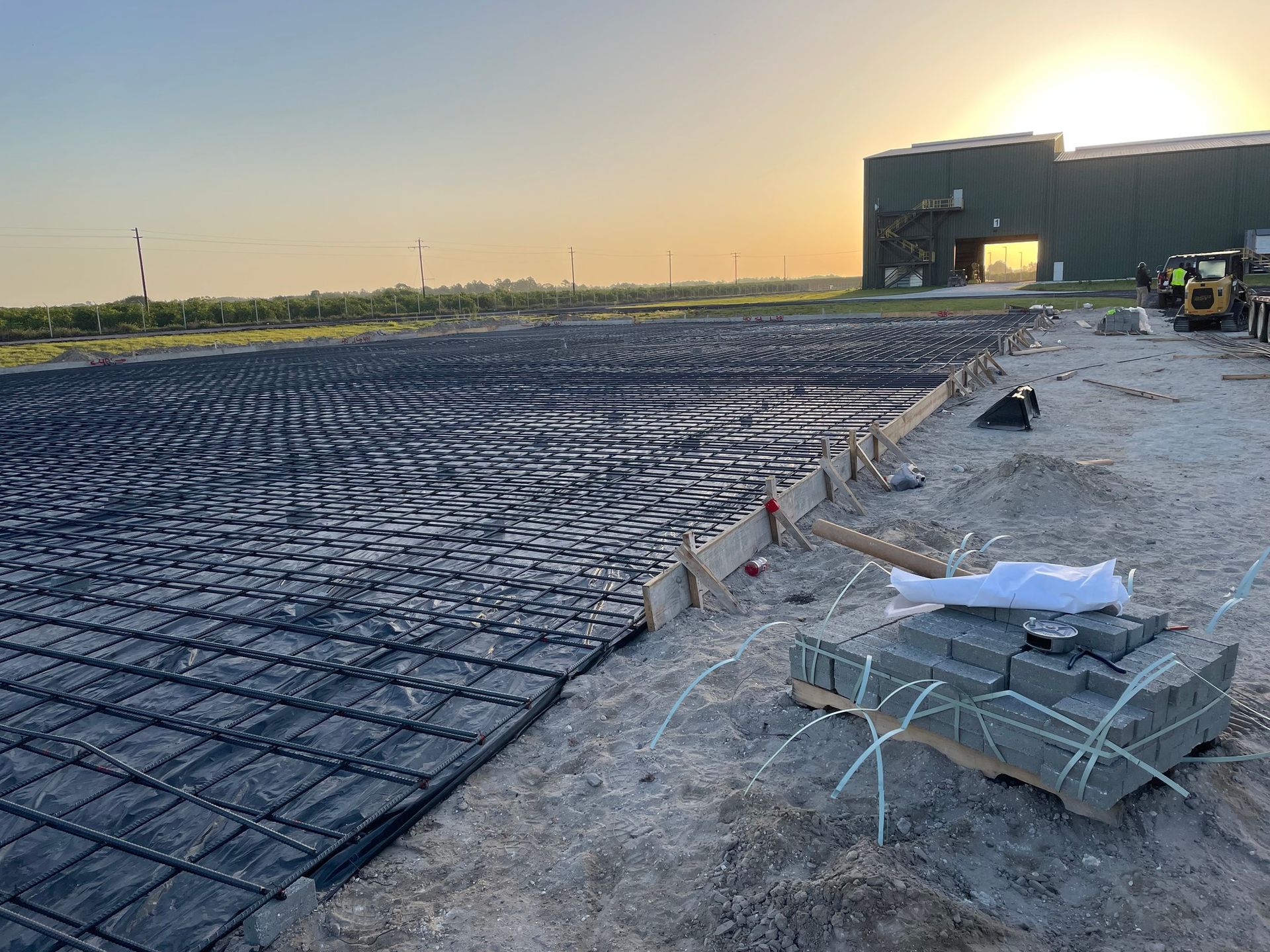 A large concrete slab is being built in front of a large building.