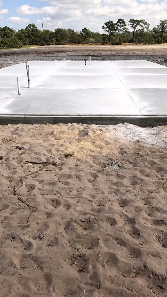 A concrete slab is sitting on top of a sandy field.