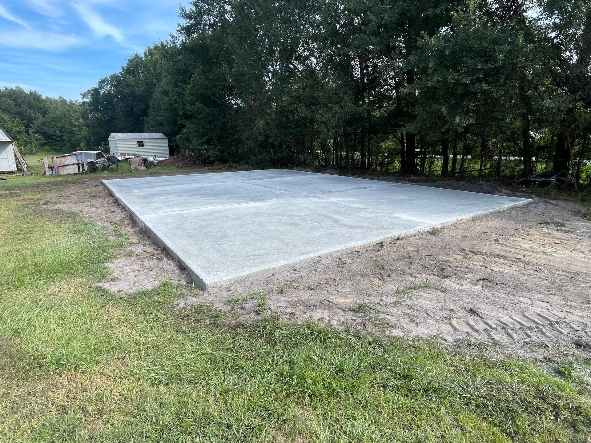 A large concrete slab is sitting in the middle of a grassy field.