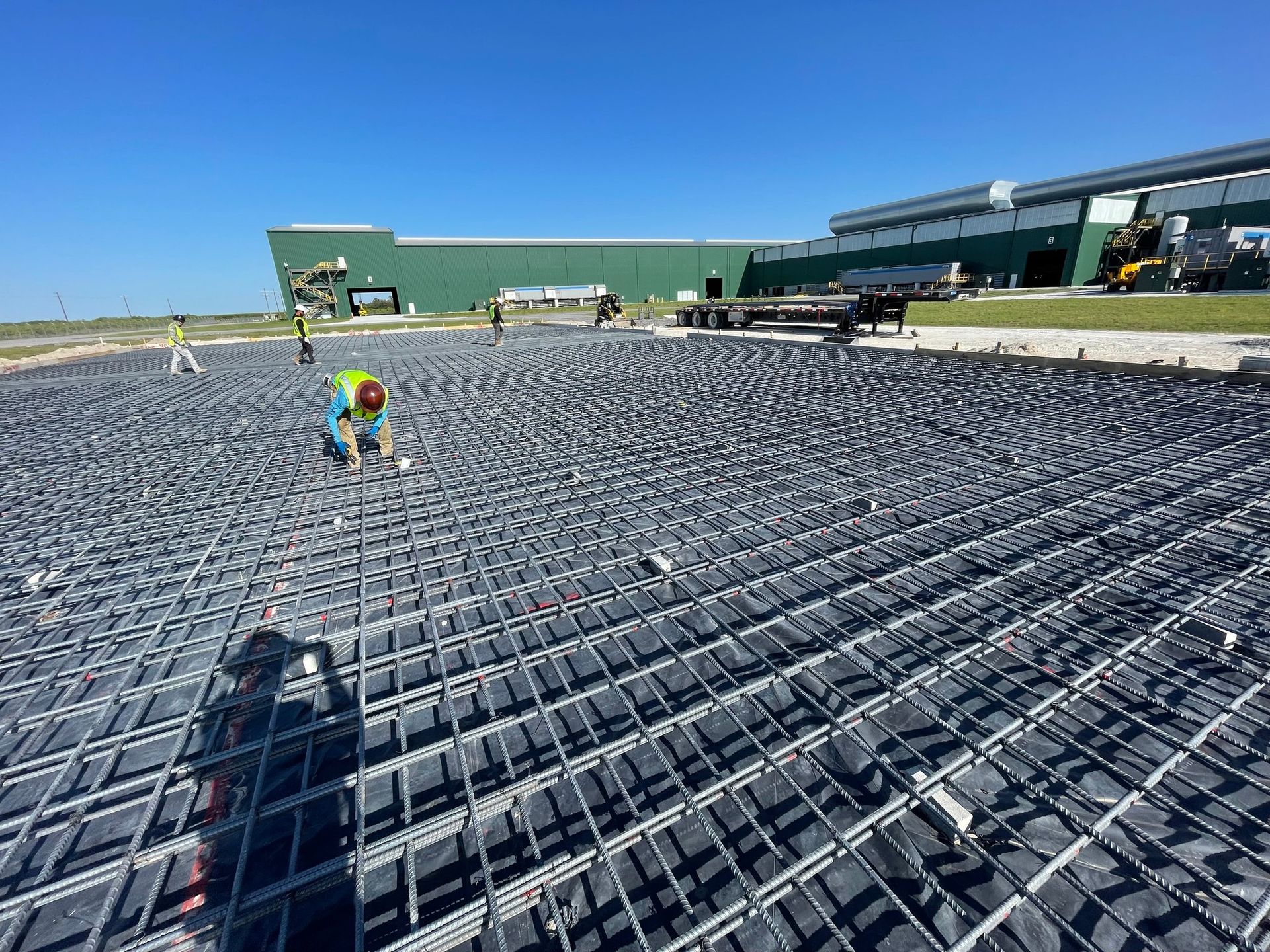 A group of construction workers are working on a concrete floor.