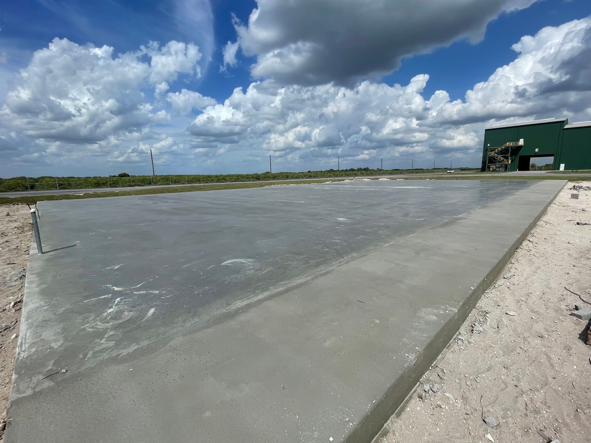 A concrete road with a green building in the background