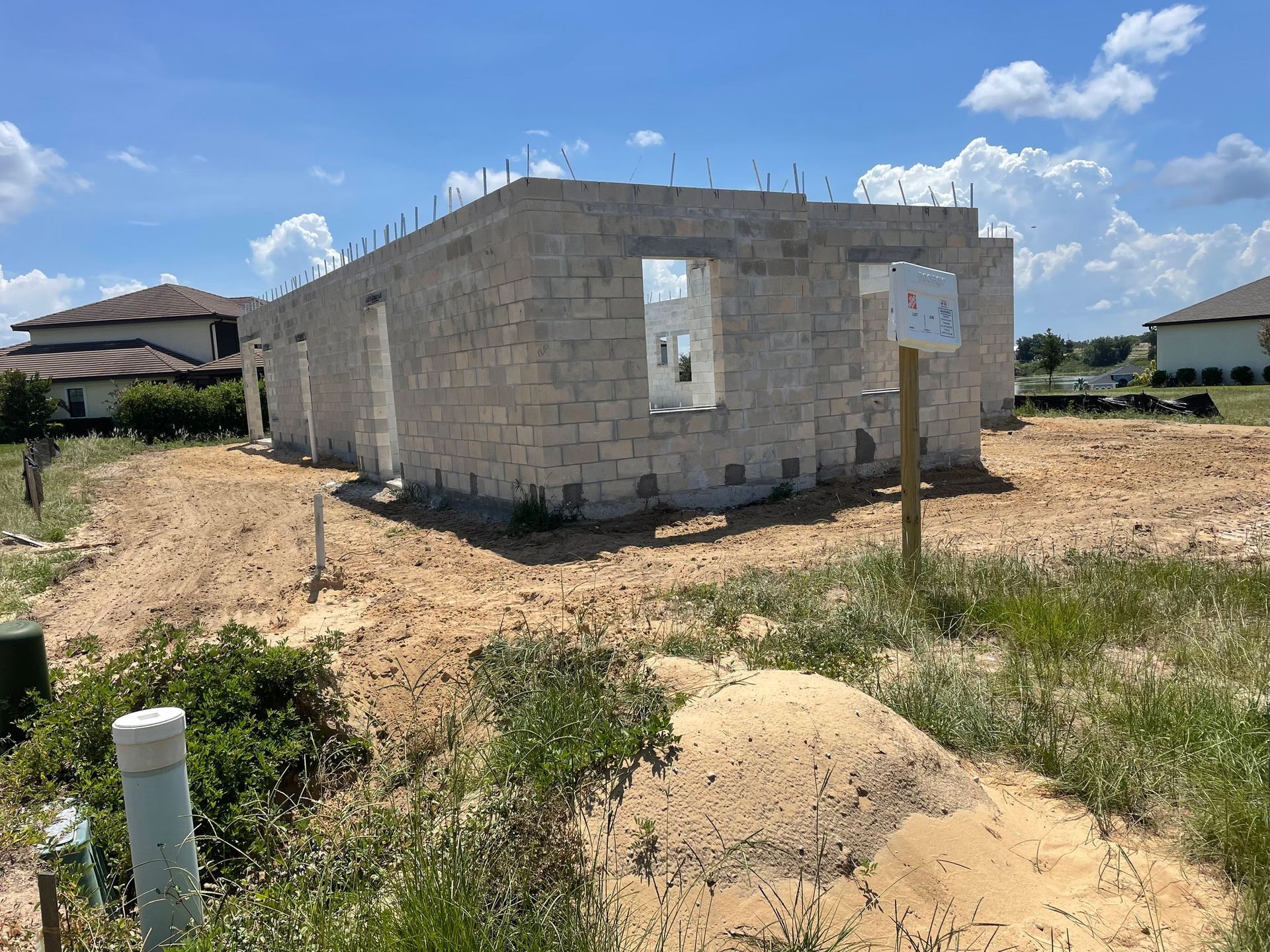 A house is being built in the middle of a dirt field.