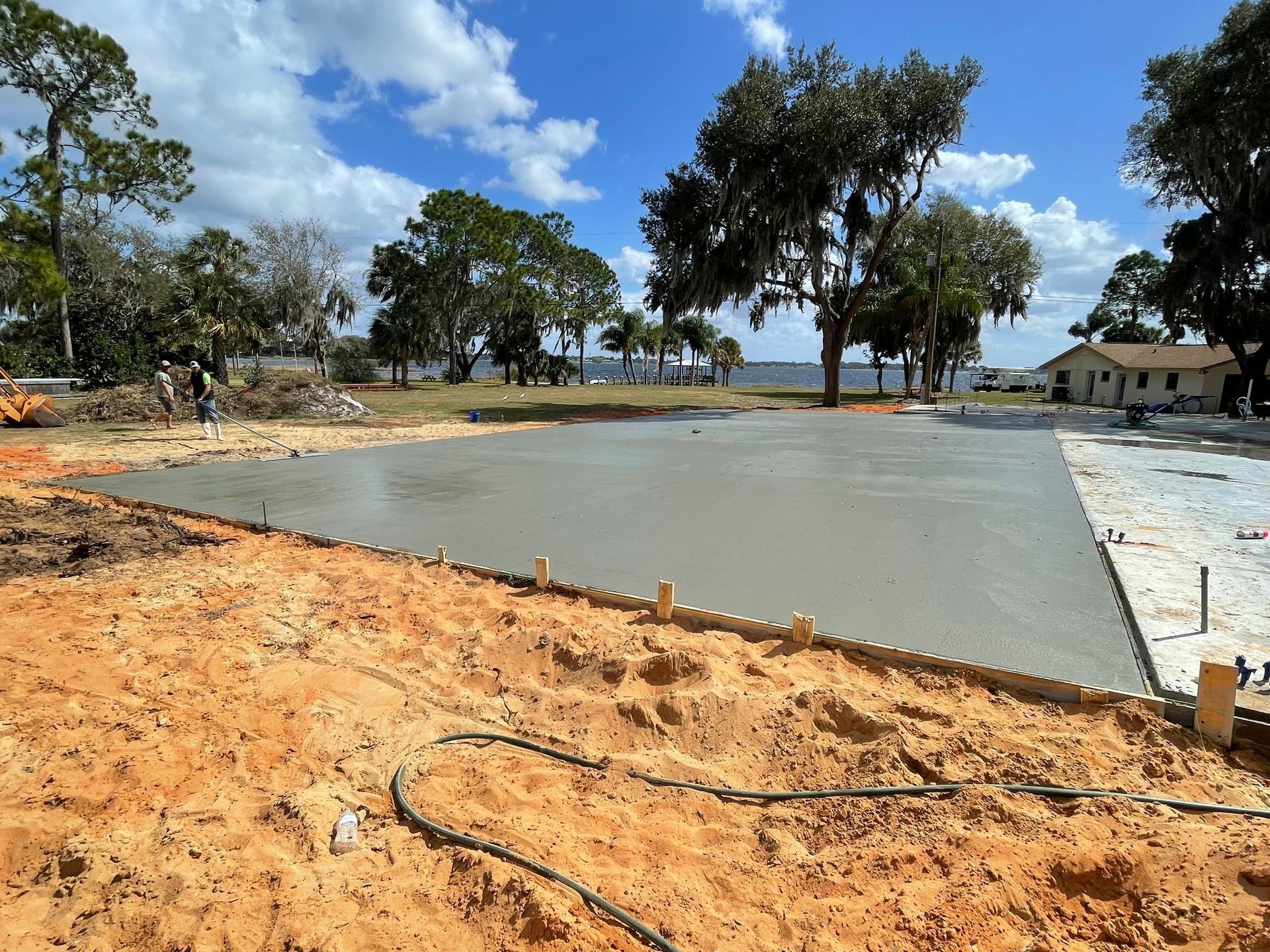 A concrete floor is being built in a field with trees in the background.