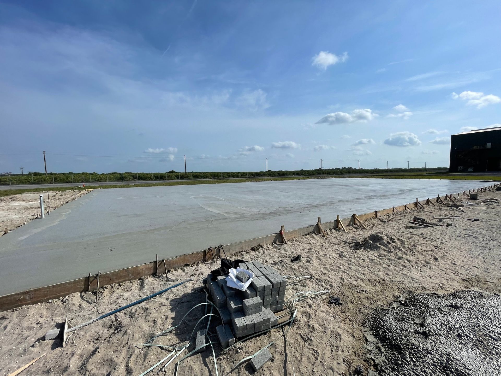 A large body of water is sitting on top of a dirt field.