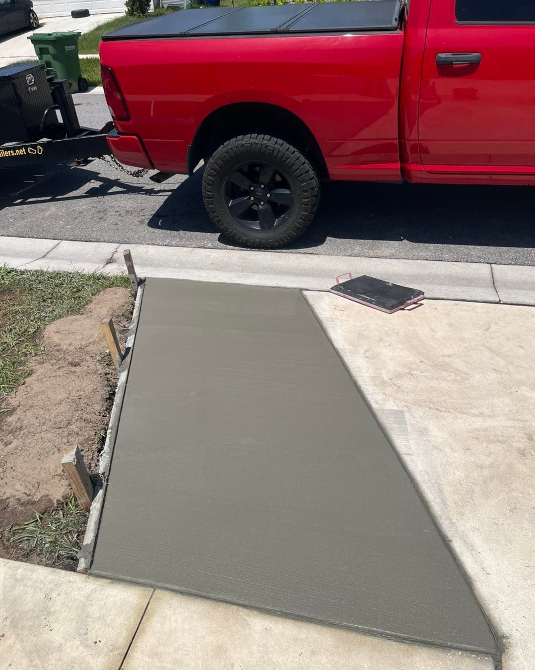 A red truck is parked next to a concrete ramp