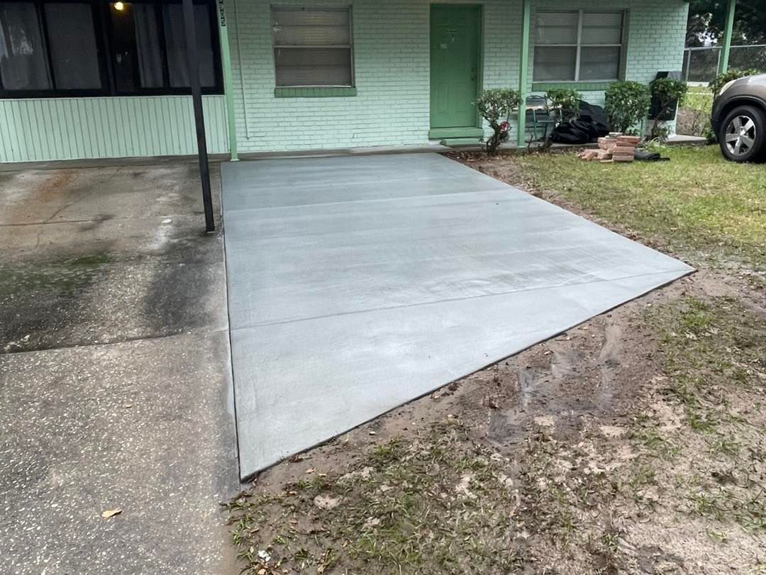 A concrete driveway is being built in front of a house.