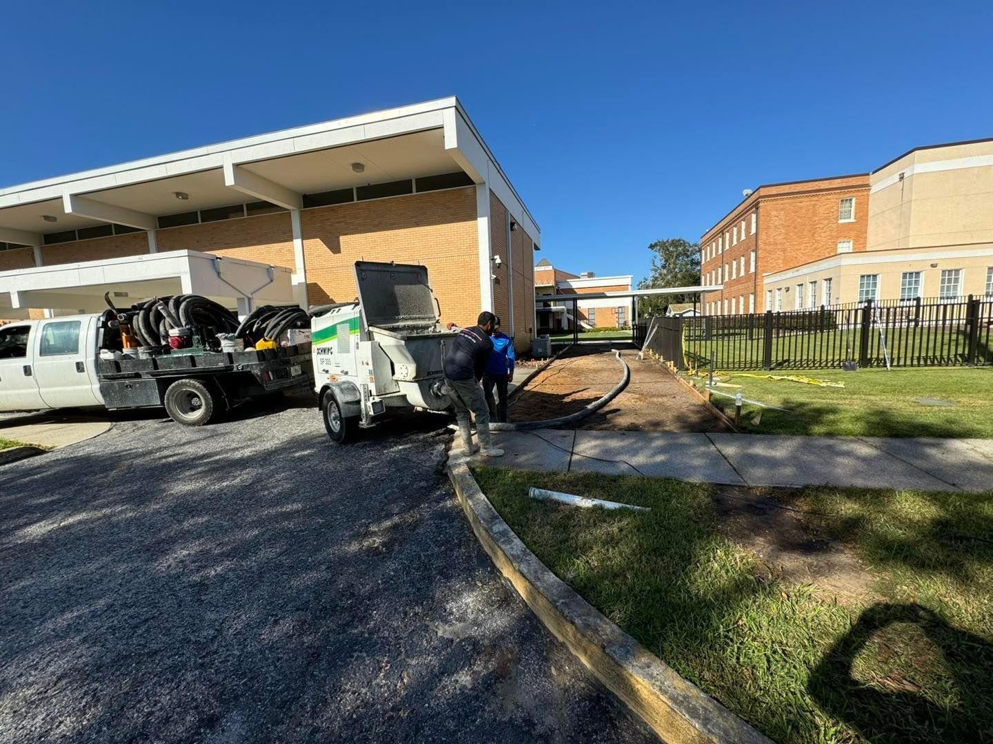A concrete pump truck is parked in front of a building.
