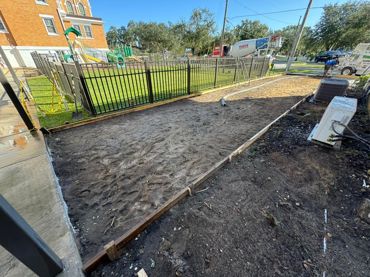 A concrete driveway is being built in front of a house.