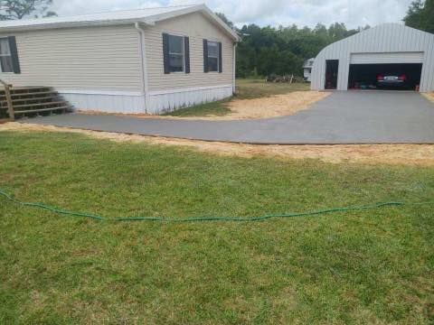 A mobile home with a driveway leading to it and a garage.