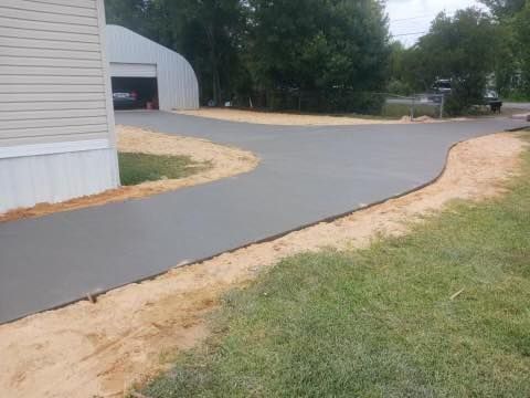 A concrete driveway is being built in front of a house.