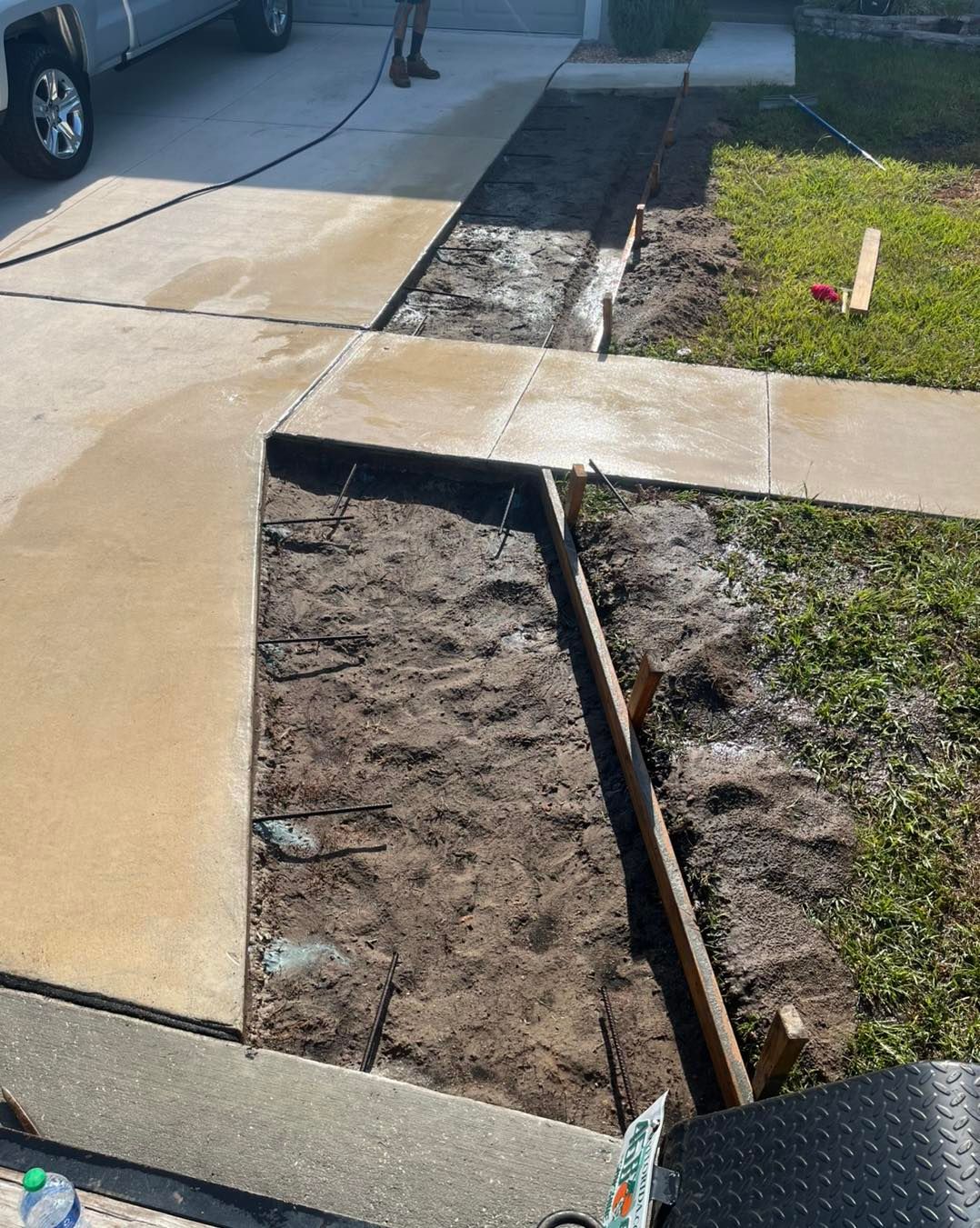 A concrete walkway is being built in front of a house.