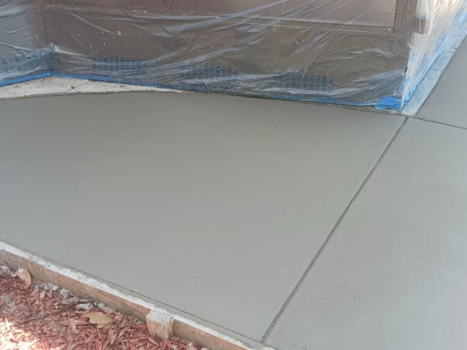 A concrete sidewalk is being painted and covered in plastic.