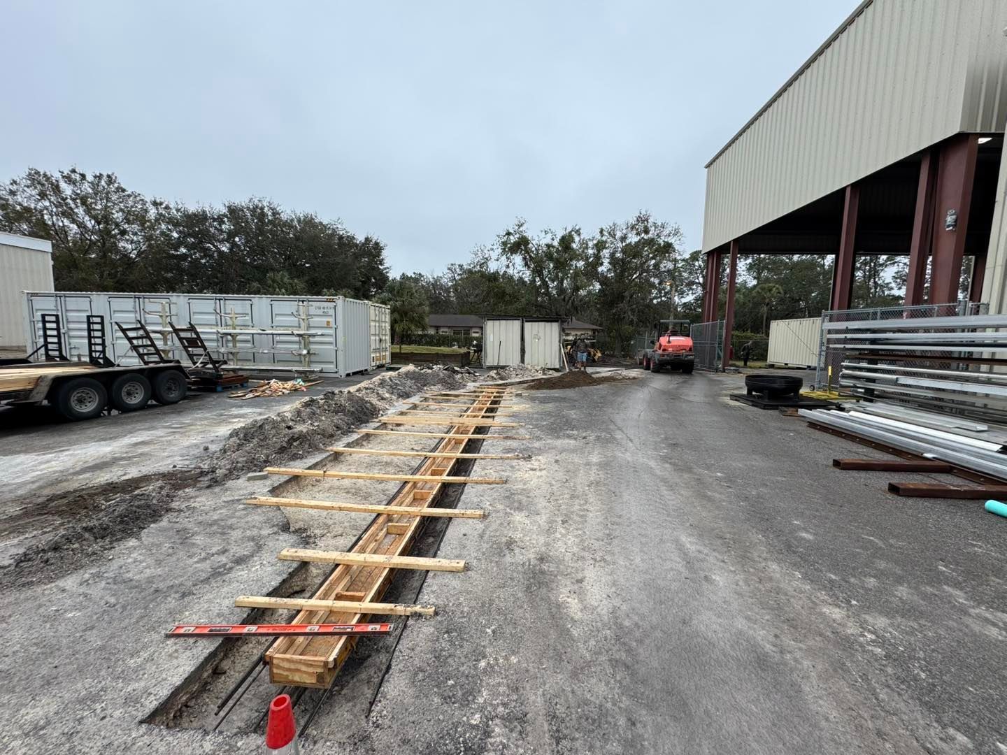A construction site with a large building in the background.