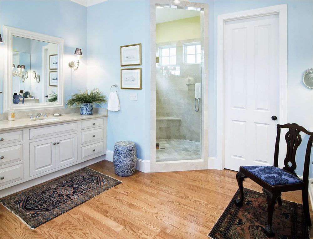 A bathroom with a walk in shower and a chair