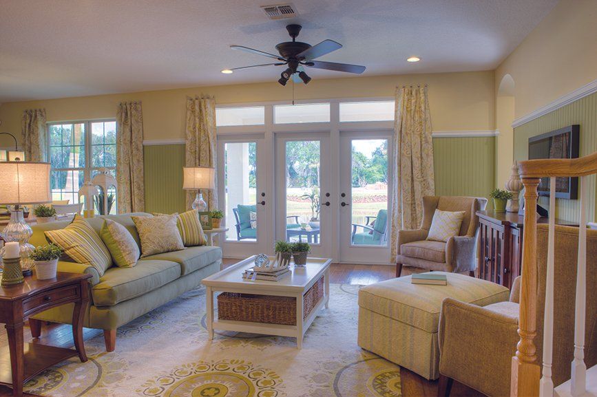 A living room filled with furniture and a ceiling fan.