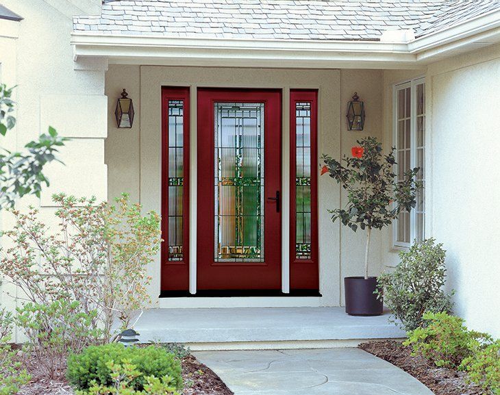 A white house with a red door and a stained glass window