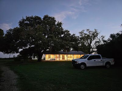 A white truck is parked in front of a house at night