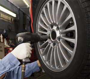 Mechanic Tightening Lug Nuts on Car Tire