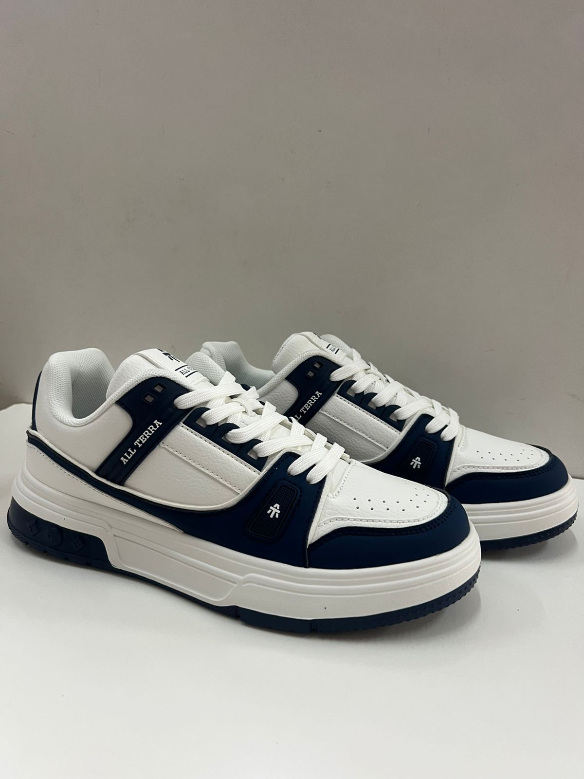 Zapatillas blancas y azul marino con suela gruesa blanca, para interior.