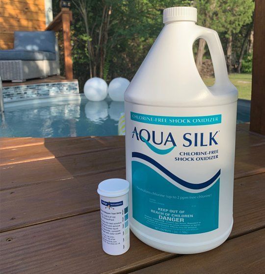 A gallon of aqua silk sits on a wooden deck