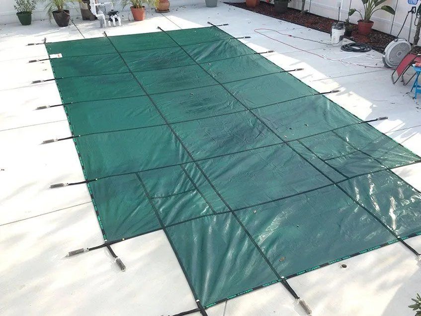 A large green tarp is sitting on top of a white tiled floor.