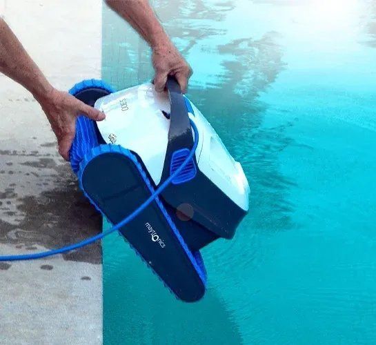 A person is cleaning a pool with a robotic vacuum cleaner