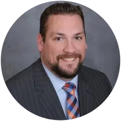 A man in a suit and tie is smiling in a circle.