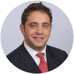 A man in a suit and tie is smiling in a circle.