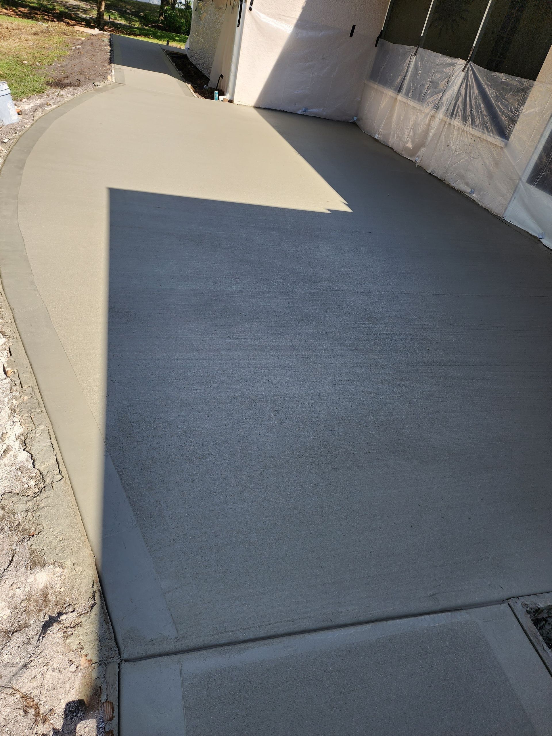 A concrete driveway is being built in front of a house.