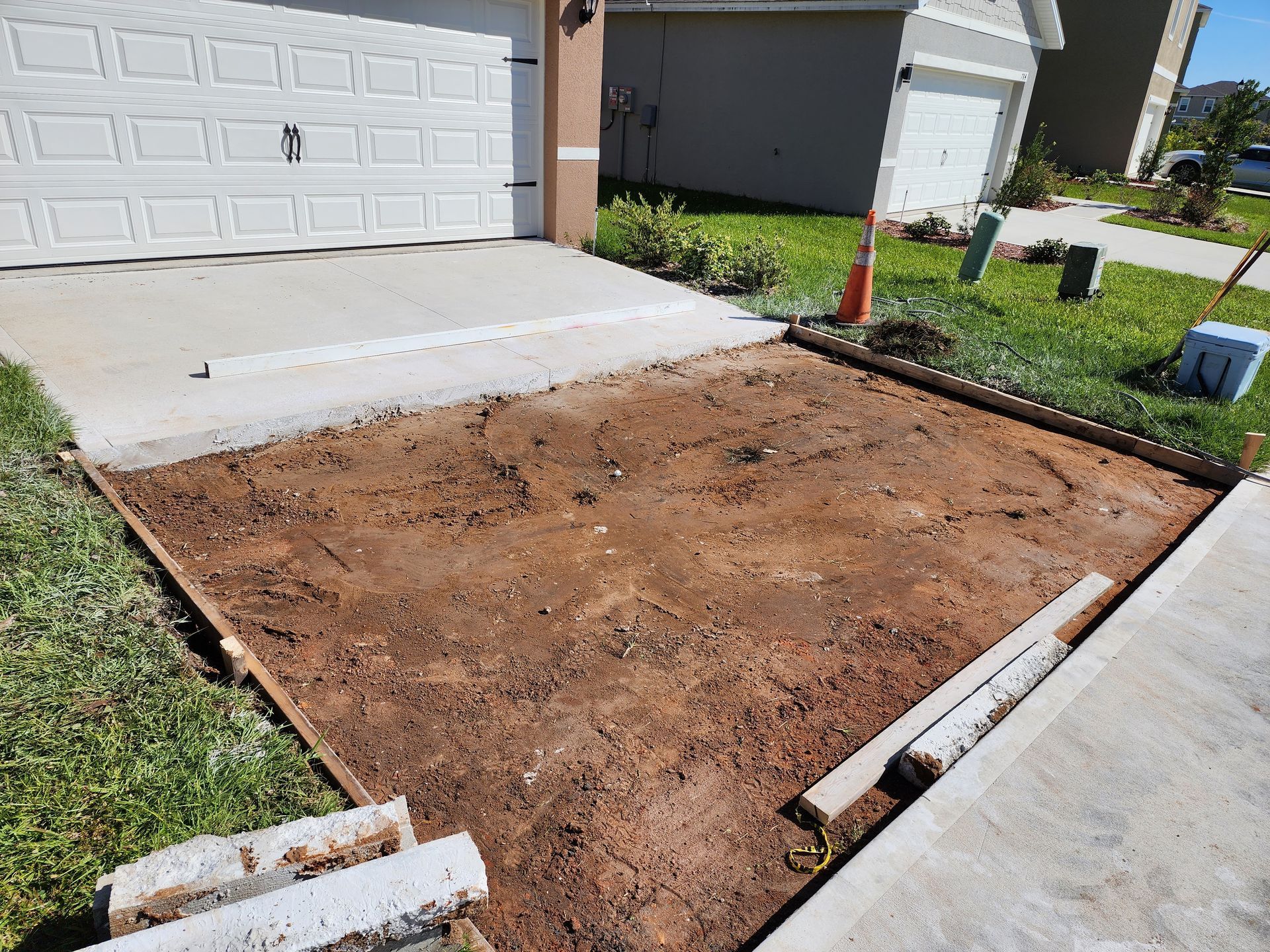 A concrete driveway is being built in front of a house