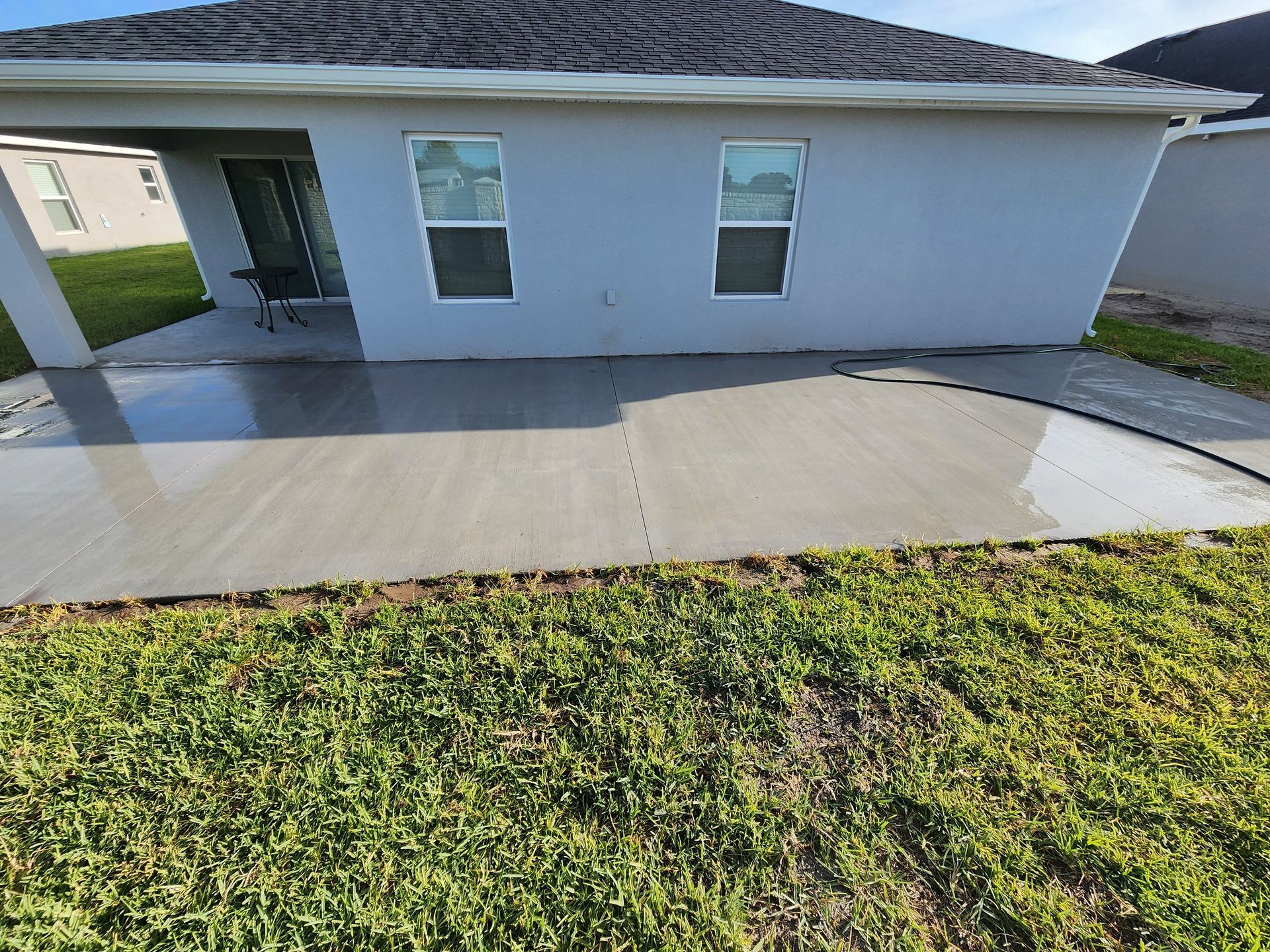 A white house with a concrete walkway in front of it.