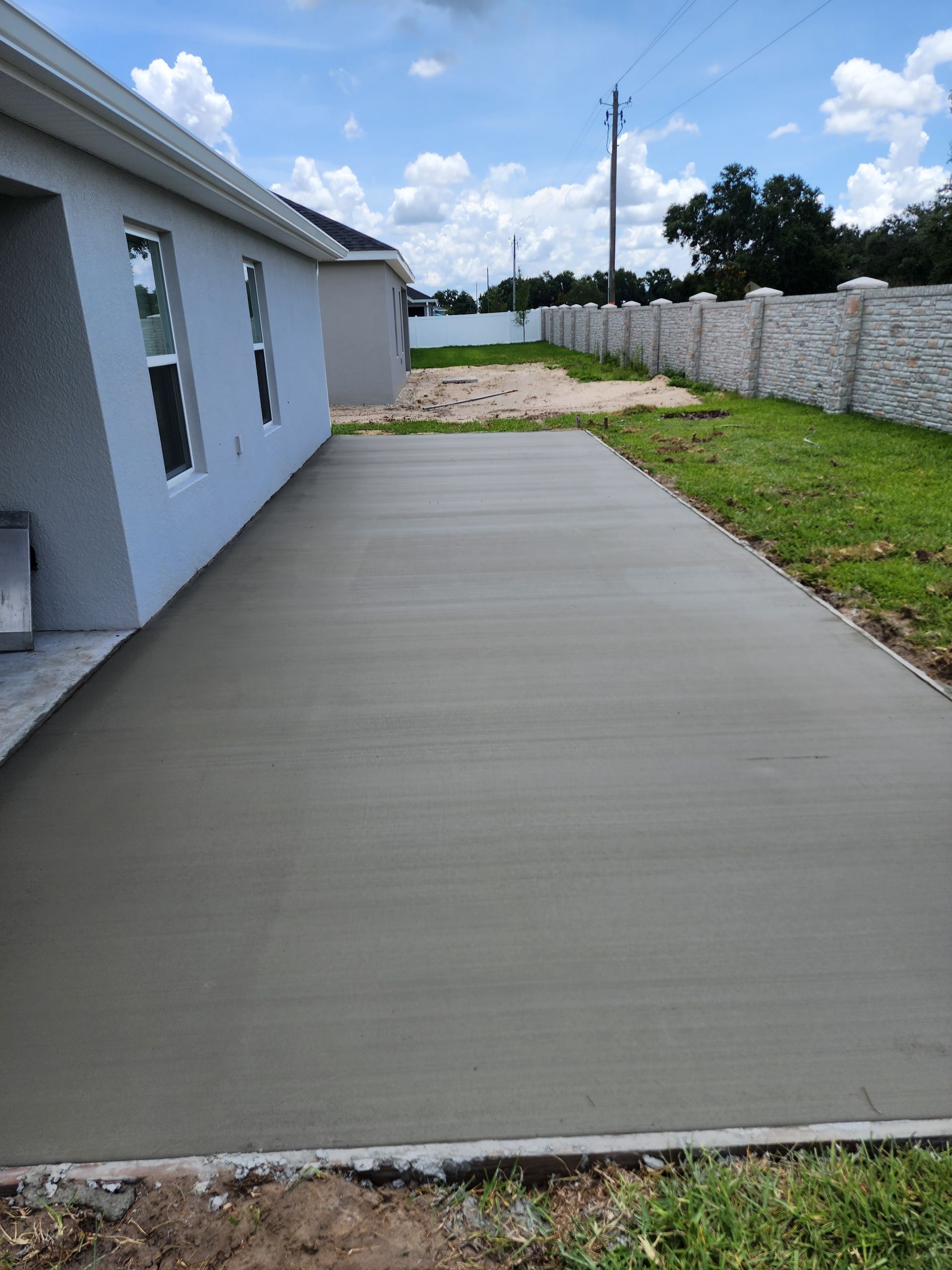 A concrete driveway is being built in front of a house.